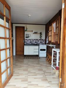 a kitchen with white appliances and a wooden door at Chacara Pôr do Sol Capivari in Campina Grande do Sul