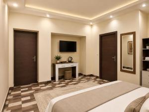 a bedroom with a bed and a tv on the wall at Pyramids Front Gate Hotel in Cairo