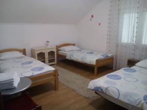 a room with two beds and a table in it at Guest House Star in Međugorje