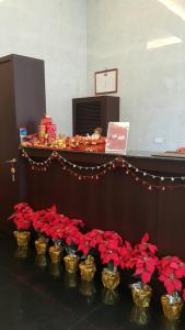 una fila di fiori rossi in contenitori dorati di Gold Sand Hotel a Hsinchu