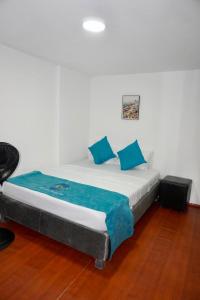 a large bed with blue pillows in a room at MANDA PARaDISE HOUSE in Cartagena de Indias
