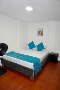 a bed with blue pillows in a room at MANDA PARaDISE HOUSE in Cartagena de Indias