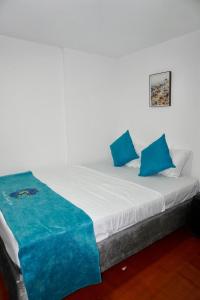 a white bed with blue pillows on top of it at MANDA PARaDISE HOUSE in Cartagena de Indias +28 photos