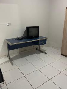 a desk with a tv on top of it in a room at Pousada de Sá in Uberlândia