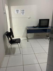 a room with a desk with a chair and a computer at Pousada de Sá in Uberlândia