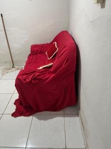 a red blanket sitting on the floor of a room at Pousada de Sá in Uberlândia