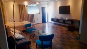 a room with a bed and a couch and chairs at Complejo Terranova in Aimogasta