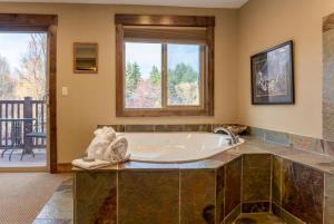 a large tub in a bathroom with a balcony at Duck Inn Lodge in Whitefish +41 photos