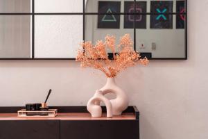 a white vase with flowers in it on a desk at Kumbaya Apartments in Achimota