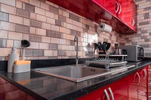 a kitchen counter with a sink and a microwave at Kumbaya Apartments in Achimota +10 photos