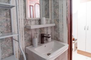 a bathroom with a sink and a mirror at Kumbaya Apartments in Achimota