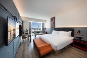 a bedroom with a large white bed and a living room at SSAW Yintai Boutique Hotel Qiandao Lake in Chun'an