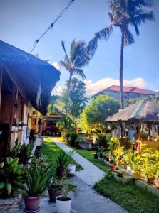 a courtyard with palm trees and a pathway at Hidden Paraiso Resort in Puerto Galera