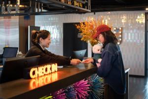 two women and a baby standing at a cash register at SSAW Yintai Boutique Hotel Qiandao Lake in Chun'an