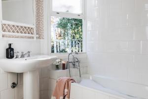 a white bathroom with a sink and a bath tub at Treehouse Southern Highlands in Moss Vale +78 photos