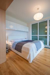 sypialnia z dużym łóżkiem i dużym oknem w obiekcie SunnyHome Baltycka 10 w Świnoujściu