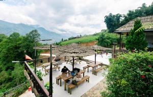 a group of people sitting on benches under an umbrella at Larosa Homestay Sapa in Sa Pả