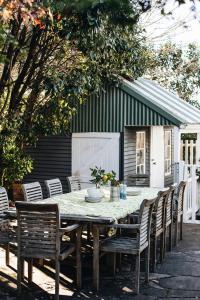 a table and chairs with a table and a building at Treehouse Southern Highlands in Moss Vale