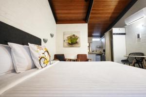 a bedroom with a large white bed and a table at Jetty Motel The Entrance in The Entrance