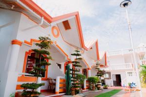 a white building with potted plants on the side at Cris Del Mar Resort in Bolinao
