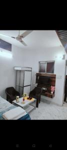 a living room with a television and a table and chairs at Agrasen Homestay in Prayagraj