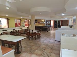 a restaurant with tables and chairs and a kitchen at Hotel Calima in Quito