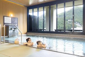 two people laying in a swimming pool at Ooedo Onsen Monogatari Premium Gero Honkan in Gero +53 photos