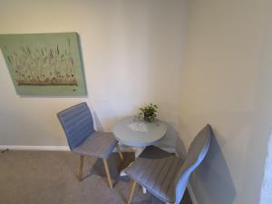 a table and chairs in a room with a painting at Monarch Park Studio in Cambridge +2 photos