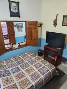 a bedroom with a bed and a flat screen tv at Hotel Atenas in Jericó