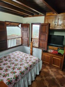 a bedroom with a bed and a flat screen tv at Hotel Atenas in Jericó