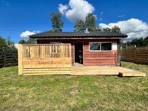 a smallshed with a wooden deck in a yard at Cabaña la Concepción 1 in Cunco