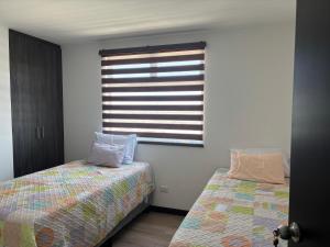 a bedroom with two beds and a window at Escápate- Roomgt in Boca Monte +11 photos