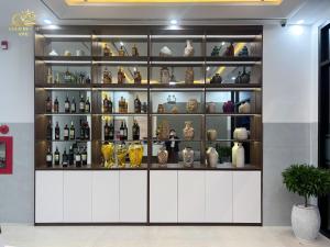 a display cabinet filled with lots of bottles and vases at Hotel Gold Beach in Phương Phi