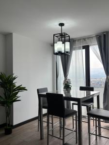 a dining room with a table and chairs and a window at Escápate- Roomgt in Boca Monte