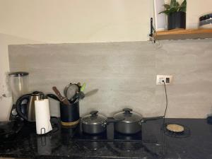 a stove top with pots and pans on a counter at Monoambiente Privado in Luque