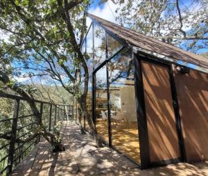a house with a glass door on a deck at Cabaña Gokotta, Punta del Bosque in Huasca de Ocampo +19 photos