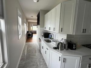 a kitchen with white cabinets and a sink at Airport room with free parking in Boston