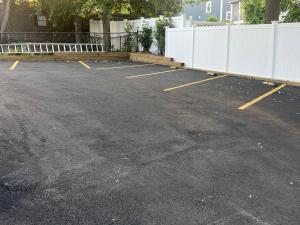 an empty parking lot with a white fence at Airport room with free parking in Boston