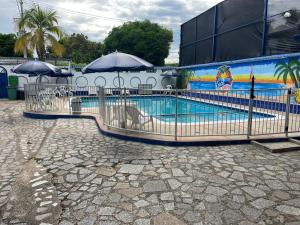 a pool with umbrellas and chairs and a swimming pool at Guiapa en melgar in Melgar