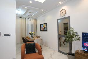 a living room with a table and a clock on the wall at Le Cocon coloré Work and Chill KÉgué in Avéimé