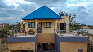 a house with a blue roof on top of it at Le Cocon coloré Work and Chill KÉgué in Avéimé