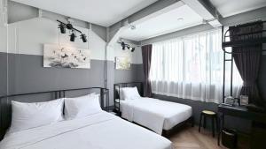 a hotel room with two beds and a window at Talakkia Boutique Hotel in Bangkok