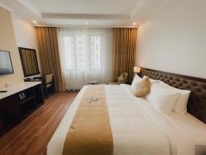 a hotel room with a large bed and a desk at ocean dragon in Ha Long