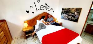 a man and a woman sitting on a bed at Romantic Suite with Pool in Fortuna +12 photos