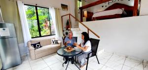 a man and a woman sitting at a table in a kitchen at Romantic Suite with Pool in Fortuna