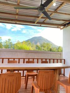 a large table with chairs and a mountain in the background at Batur Tropical in Kintamani