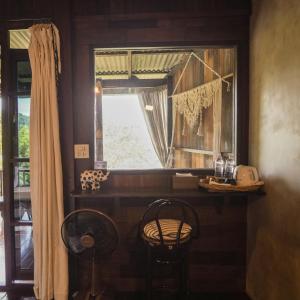a window in a room with two chairs and a table at ทโล้ โฮมสเตย์ เชียงใหม่ | Taloh Homestay Chiangmai in Mae On