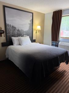a bedroom with a bed with a large picture on the wall at LaVale Inn Cumberland Area in La Vale +9 photos