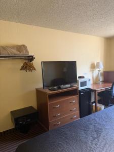 a hotel room with a television and a bed and a desk at LaVale Inn Cumberland Area in La Vale
