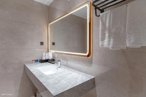 a bathroom with a sink and a large mirror at Solaya Hotel in Tài Xá